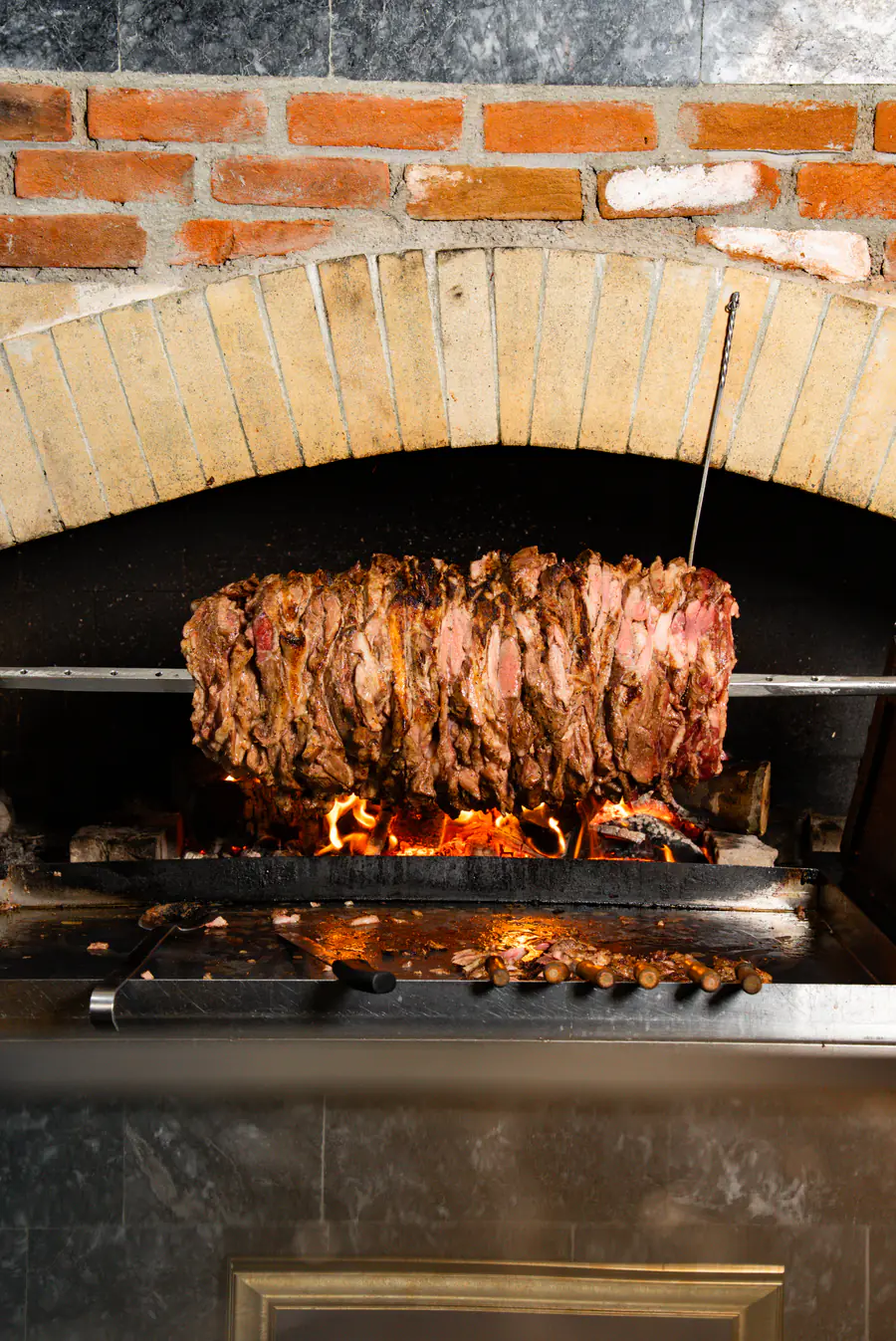Odun ateşinin üzerinde pişen cağ kebap eti, tuğla kemerli ocak